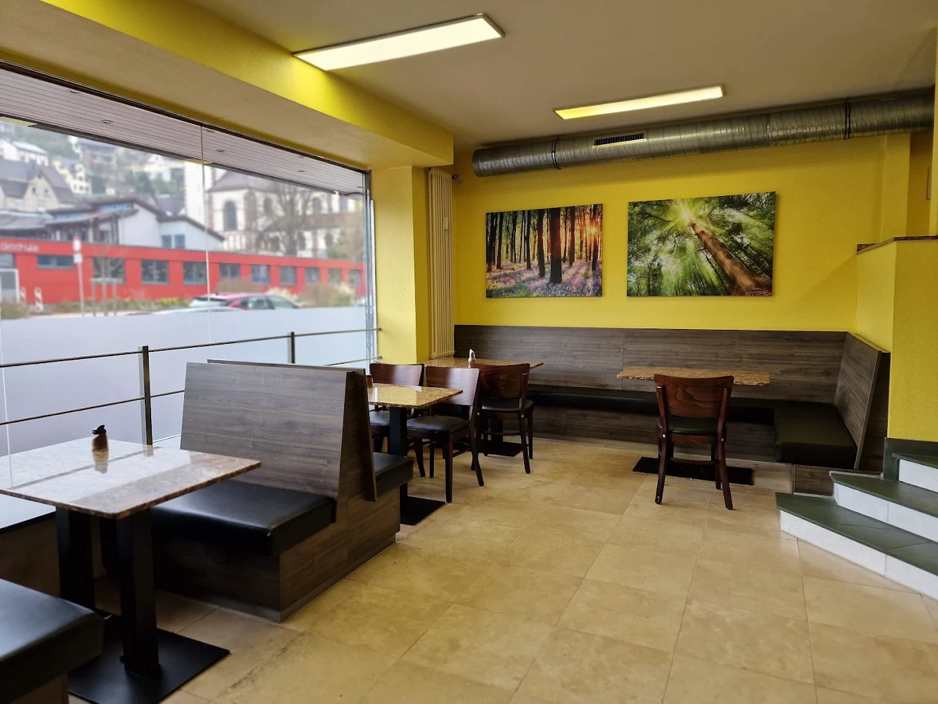 Gastraum bei Kebap Gourmet mit Sitzecke und Schwarzwald-Fotos an der Wand